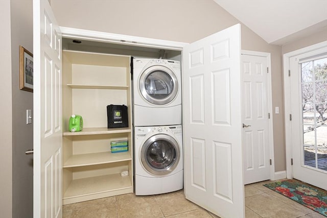 laundry room featuring stacked washer / drying machine, laundry area, and tile patterned flooring