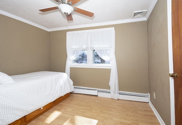 unfurnished bedroom with visible vents, a baseboard heating unit, ceiling fan, ornamental molding, and wood finished floors