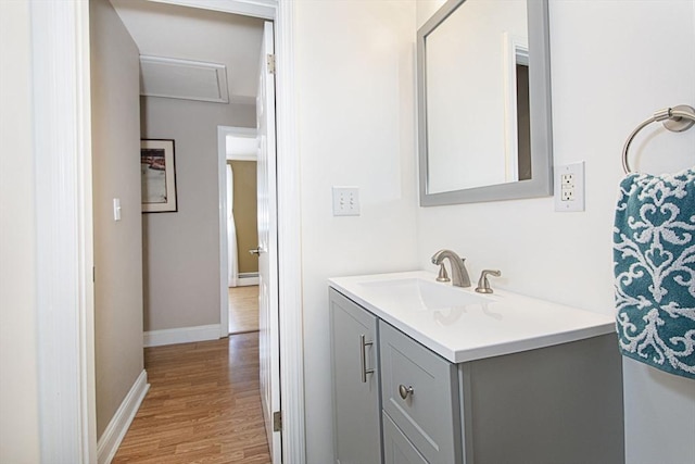 bathroom featuring vanity, wood finished floors, and baseboards