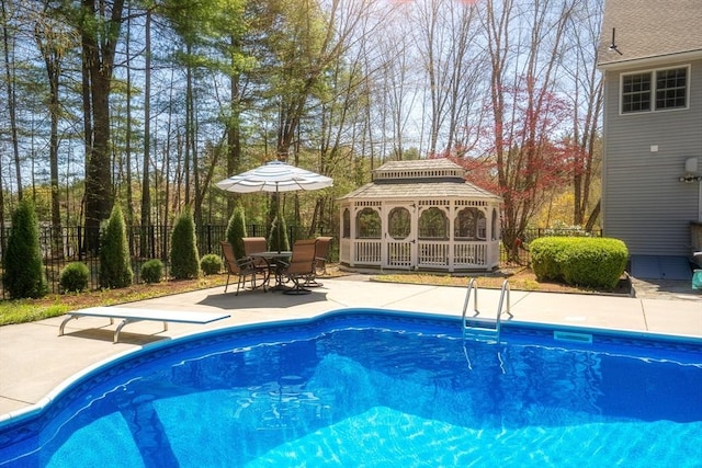 outdoor pool featuring fence, a diving board, a gazebo, and a patio area