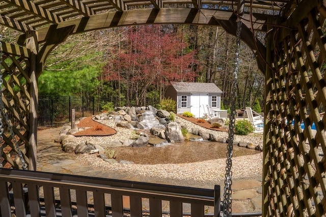 exterior space with a pergola, fence, and an outdoor structure