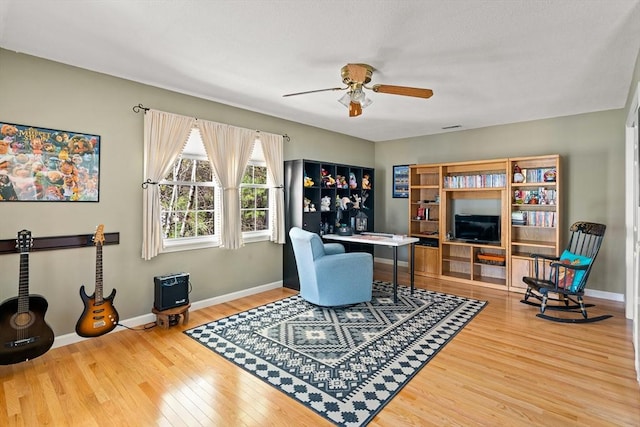 office area featuring a ceiling fan, baseboards, and wood finished floors