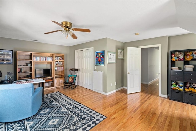 living room with baseboards, a ceiling fan, light wood-style flooring, and visible vents