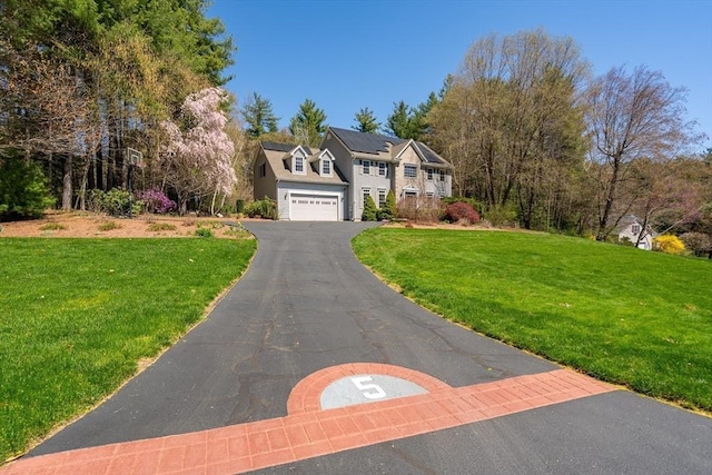 traditional home with driveway and a front lawn