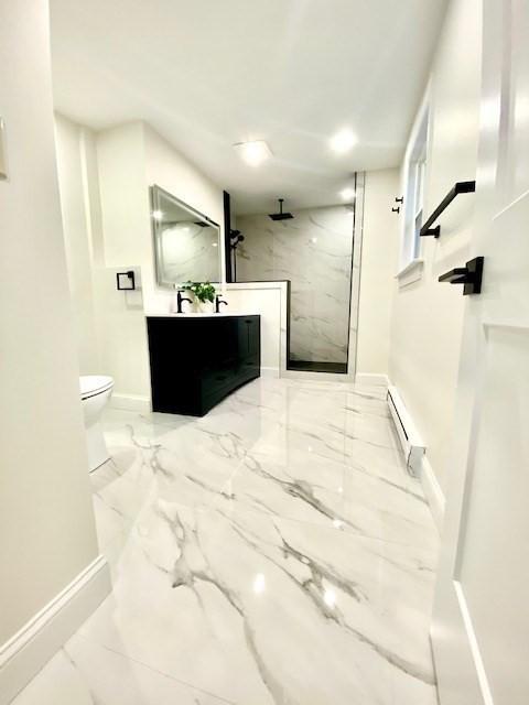 bathroom featuring vanity, a baseboard radiator, toilet, and tiled shower