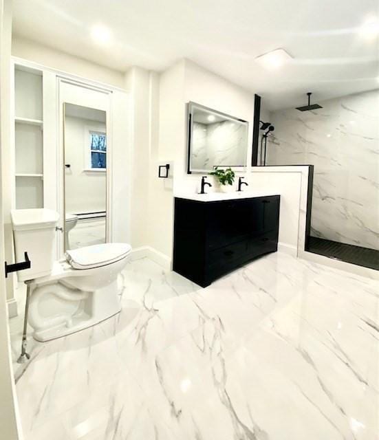 bathroom with a tile shower, vanity, and toilet