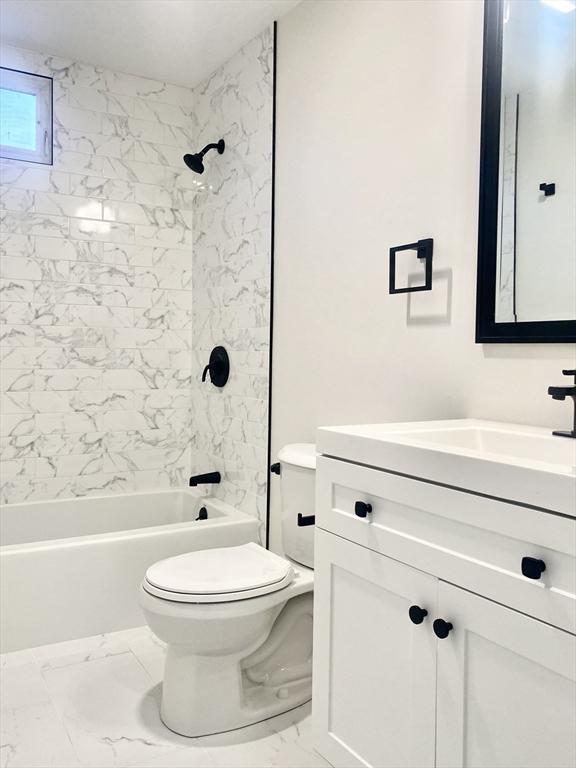 full bathroom with vanity, toilet, and tiled shower / bath