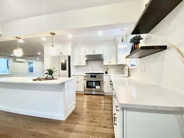 kitchen with white cabinetry, fridge, pendant lighting, and stainless steel stove