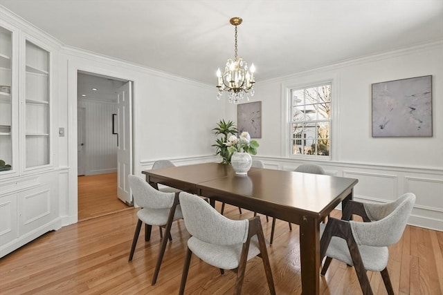 15 Alden Rd, Wellesley, MA 02481 - dining space with a chandelier, ornamental molding, a decorative wall, light wood-style floors, and built in shelves