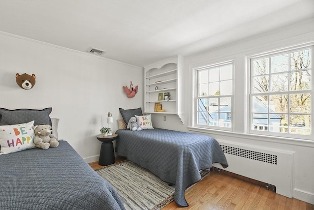 15 Alden Rd, Wellesley, MA 02481 - bedroom with radiator heating unit, light wood-style floors, and crown molding