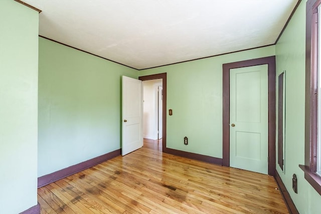 unfurnished room with light wood-type flooring and baseboards