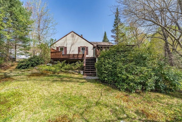 rear view of house featuring a lawn, a deck, and stairs