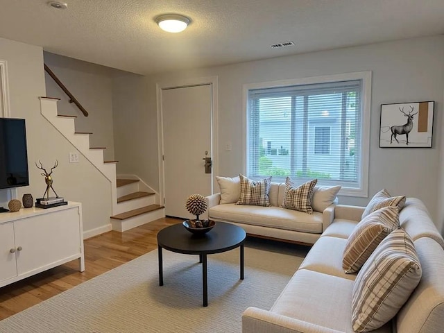 994 Washington St Unit 2, Weymouth, MA 02189 - living area with stairs, wood finished floors, a textured ceiling, and baseboards