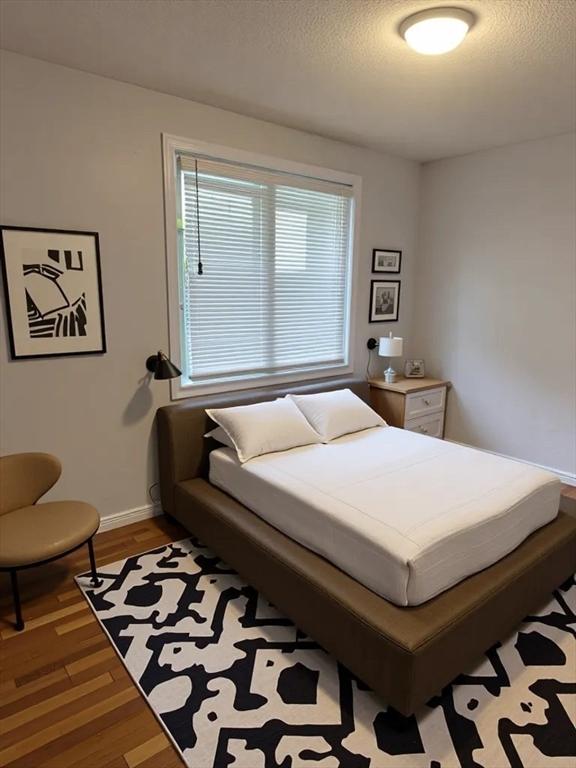 994 Washington St Unit 2, Weymouth, MA 02189 - bedroom with wood finished floors, baseboards, and a textured ceiling