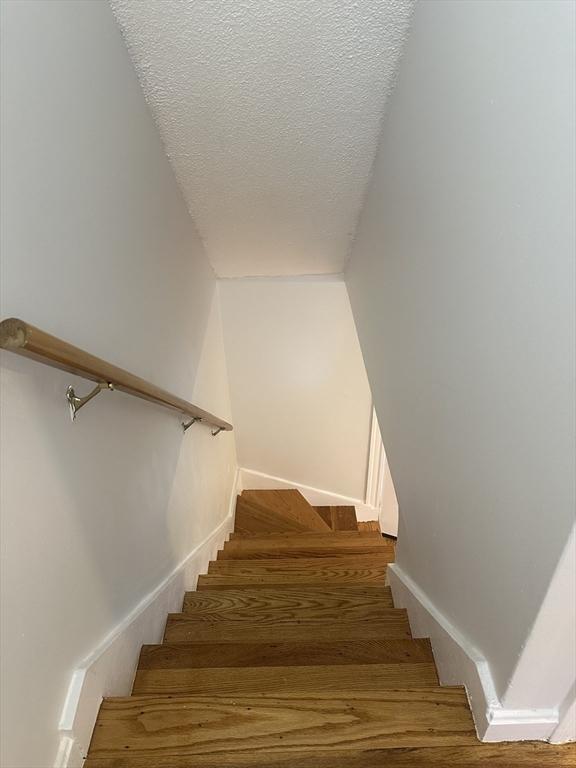 994 Washington St Unit 2, Weymouth, MA 02189 - stairs with wood finished floors, a textured ceiling, and baseboards
