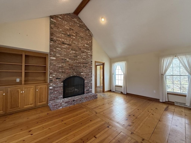unfurnished living room with baseboards, beam ceiling, light wood finished floors, a brick fireplace, and high vaulted ceiling