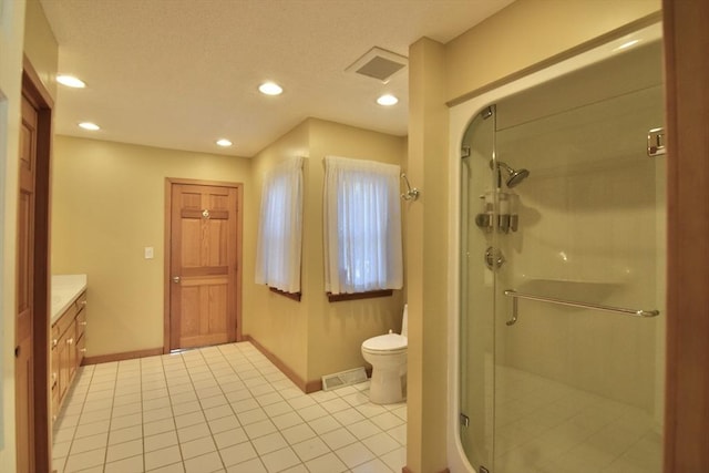 bathroom featuring tile patterned flooring, a shower stall, toilet, vanity, and baseboards