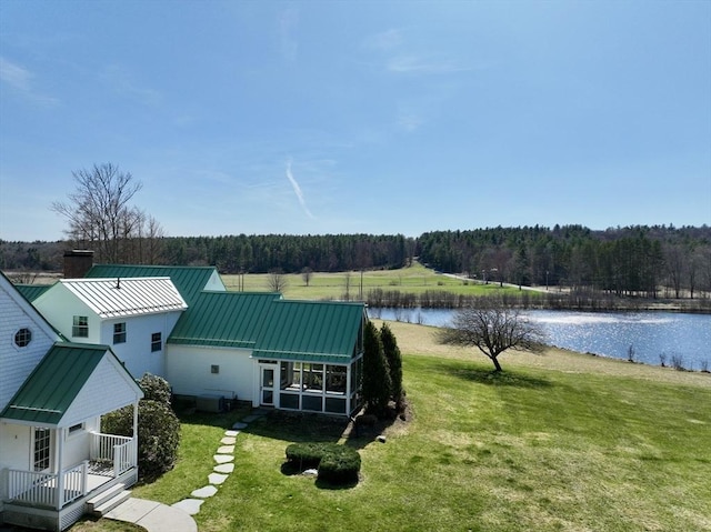 birds eye view of property with a wooded view and a water view