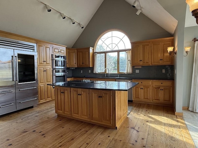 kitchen featuring a sink, a center island, track lighting, and stainless steel appliances