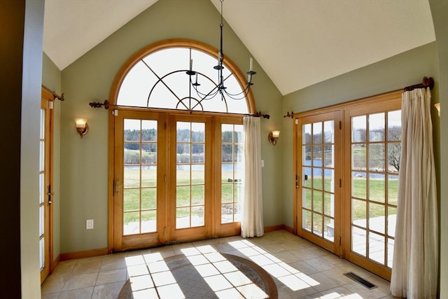 entryway featuring a water view, visible vents, vaulted ceiling, and a wealth of natural light