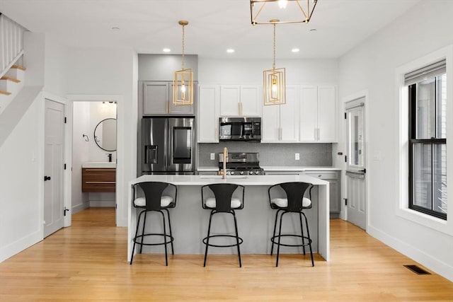 kitchen featuring a sink, a kitchen breakfast bar, a center island with sink, and stainless steel appliances