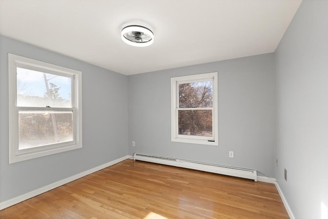 unfurnished room featuring light hardwood / wood-style floors and baseboard heating