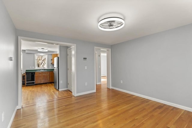 unfurnished living room featuring light wood-type flooring and sink