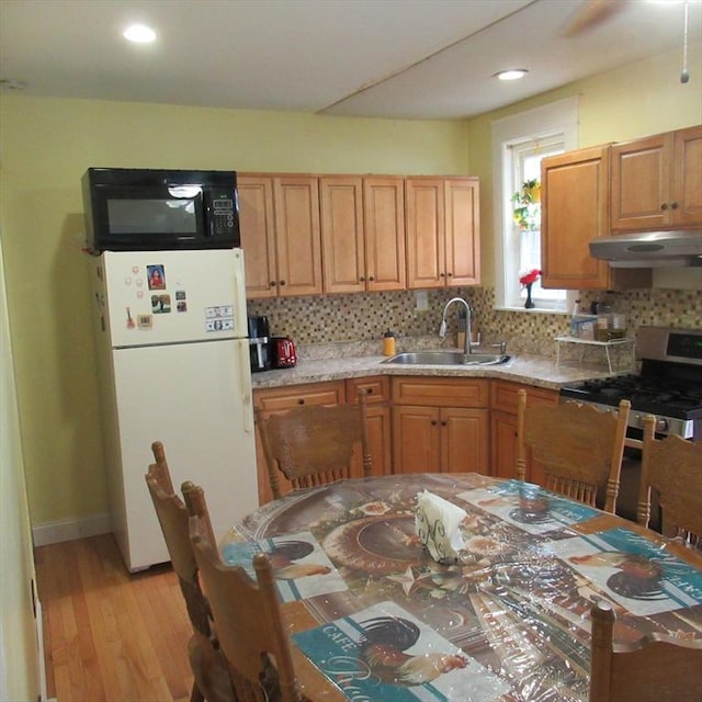 85-87 Belrose Ave, Lowell, MA 01852 - kitchen with freestanding refrigerator, black microwave, ventilation hood, stainless steel gas range, and tasteful backsplash