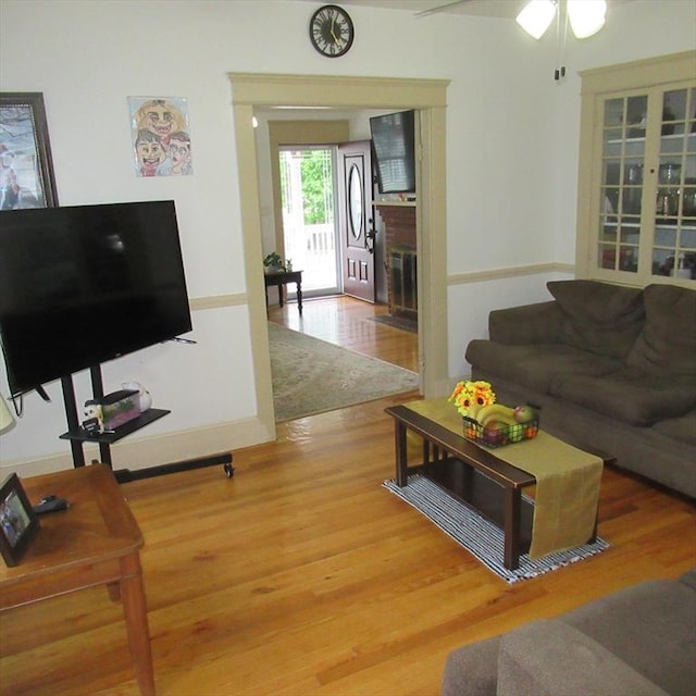 85-87 Belrose Ave, Lowell, MA 01852 - living room featuring wood finished floors, a brick fireplace, and a ceiling fan