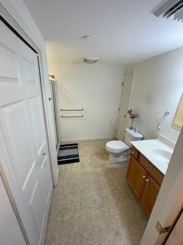 bathroom with vanity, a shower stall, and toilet