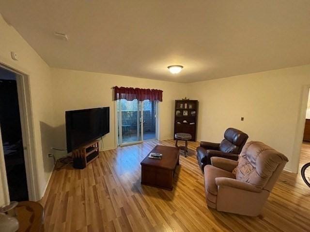 living area with light wood-type flooring and baseboards