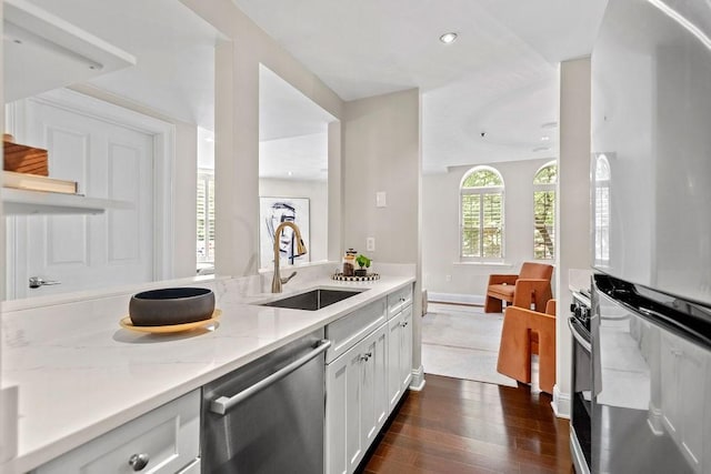 1682 Washington St Unit 8, Boston, MA 02118 - kitchen with stainless steel dishwasher, freestanding refrigerator, dark wood-style flooring, white cabinets, and light stone counters