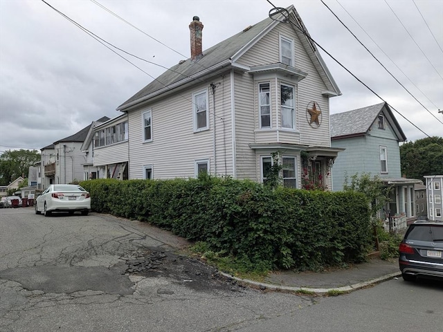 15 10th, Lowell, MA 01850 - view of property exterior with a chimney and a shingled roof