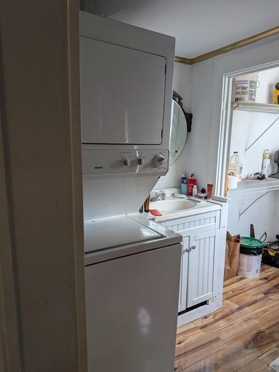15 10th, Lowell, MA 01850 - laundry room featuring stacked washer / drying machine and light wood-style flooring