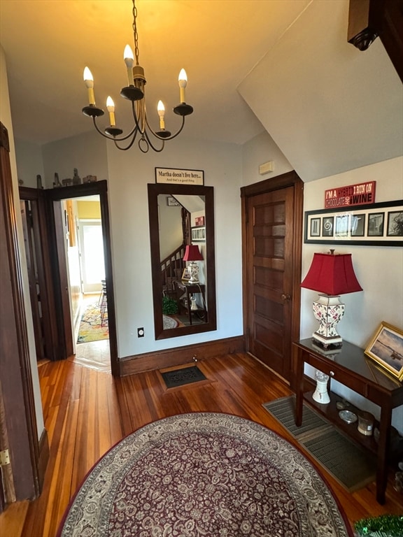 corridor with a chandelier and dark hardwood / wood-style flooring