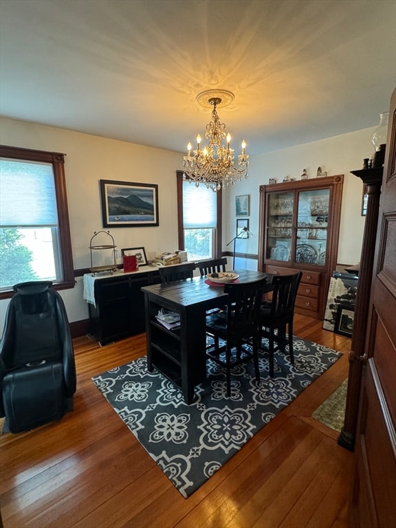 dining space featuring a wealth of natural light, wood-type flooring, and an inviting chandelier