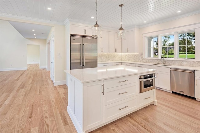 1 Wilsons Ln, Edgartown, MA 02539 - kitchen featuring stainless steel appliances, a sink, light countertops, ornamental molding, and tasteful backsplash