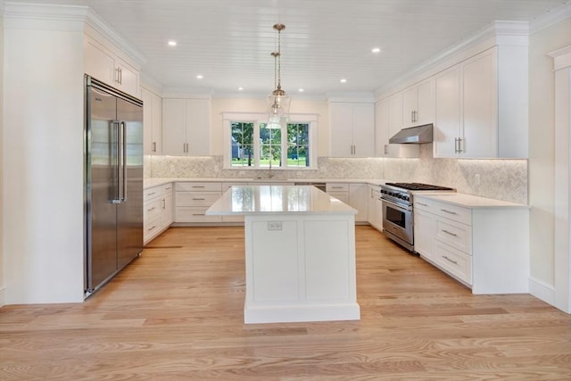1 Wilsons Ln, Edgartown, MA 02539 - kitchen with premium appliances, under cabinet range hood, light countertops, a center island, and light wood-type flooring