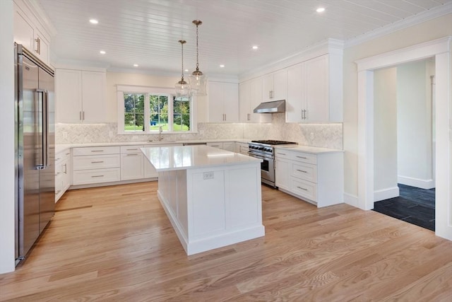 1 Wilsons Ln, Edgartown, MA 02539 - kitchen featuring premium appliances, under cabinet range hood, a sink, light countertops, and a center island