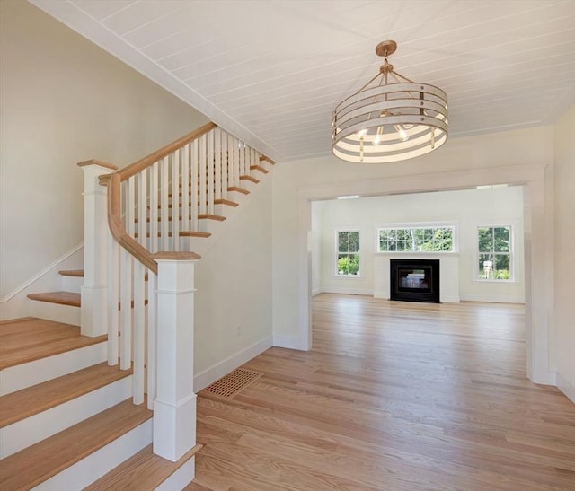 1 Wilsons Ln, Edgartown, MA 02539 - stairway with wood finished floors, baseboards, a chandelier, and a glass covered fireplace