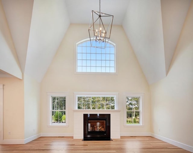 1 Wilsons Ln, Edgartown, MA 02539 - unfurnished living room featuring a chandelier, high vaulted ceiling, wood finished floors, and healthy amount of natural light