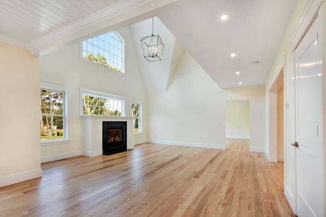 1 Wilsons Ln, Edgartown, MA 02539 - unfurnished living room featuring light wood-style flooring, a fireplace with flush hearth, a chandelier, baseboards, and crown molding