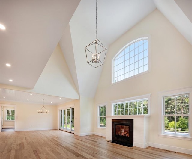 1 Wilsons Ln, Edgartown, MA 02539 - unfurnished living room featuring a chandelier, high vaulted ceiling, light wood-type flooring, a fireplace with flush hearth, and recessed lighting
