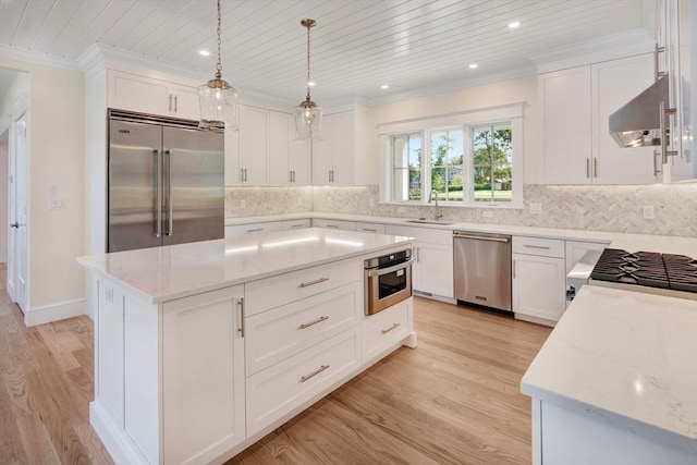 1 Wilsons Ln, Edgartown, MA 02539 - kitchen with appliances with stainless steel finishes, exhaust hood, a sink, light wood finished floors, and crown molding
