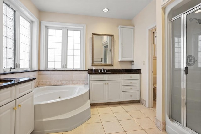 full bath with a garden tub, toilet, tile patterned flooring, vanity, and a shower stall