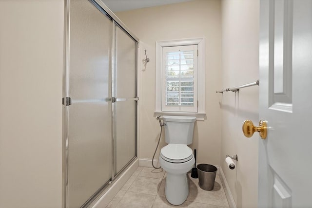 full bathroom with baseboards, tile patterned flooring, toilet, and a shower stall