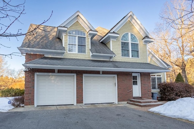 view of front of property with brick siding, aphalt driveway, and roof with shingles