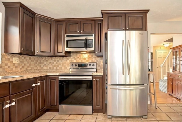 19 Crystal Way Unit 19, Bellingham, MA 02019 - kitchen with stainless steel appliances, light tile patterned floors, tasteful backsplash, and dark brown cabinets