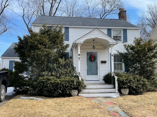 view of front of home with roof with shingles and a chimney