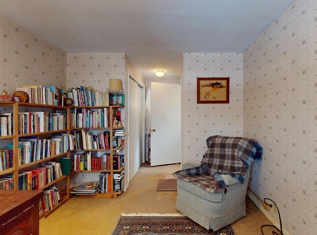 sitting room with carpet and wallpapered walls